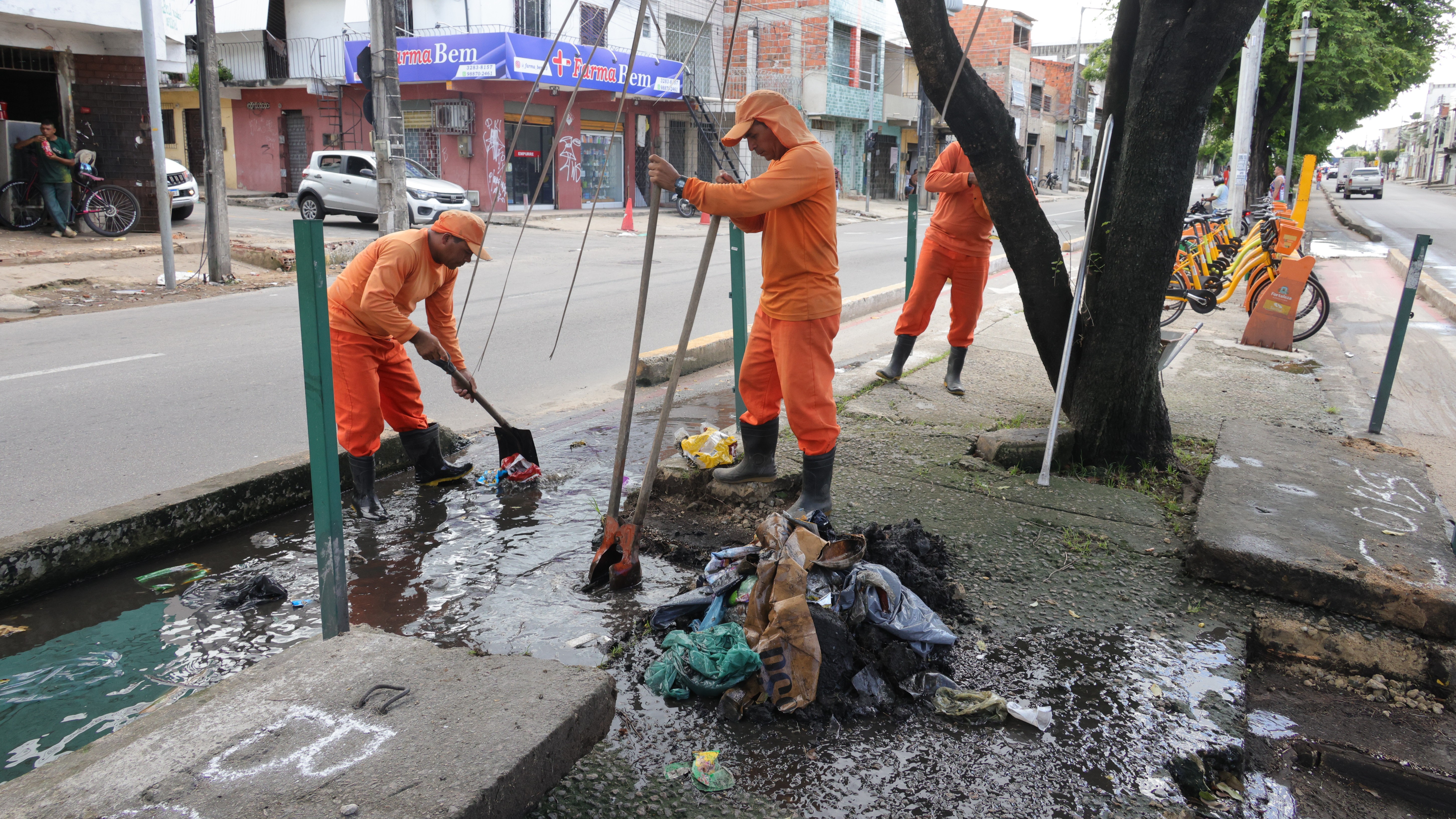 Homens limpando uma boca de lobo